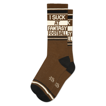 A single brown crew sock with black toes and heels. Features "I SUCK AT FANTASY FOOTBALL" text on a white band.