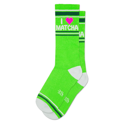 Bright green crew socks with 'I ❤️ MATCHA' text in white and a pink heart. Features white toe, heel, and striped cuffs.
