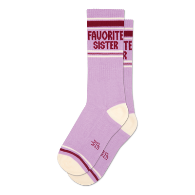 Two lavender crew socks with cream heel/toe. Maroon and white stripes on cuff, 'FAVORITE SISTER' text visible on one sock.