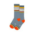 Pair of grey-blue crew socks with white "BADASS GRANDPA" text, yellow cuffs, orange heels & toes, and a grey logo.