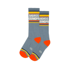 Pair of grey-blue crew socks with white "BADASS GRANDPA" text, yellow cuffs, orange heels & toes, and a grey logo.