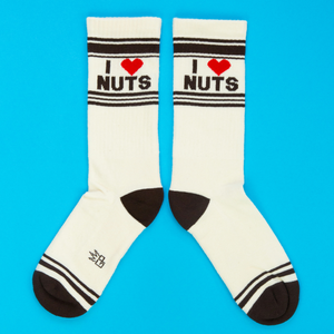 Two cream crew socks with 'I ❤️ NUTS' design, red hearts, and dark brown accents, laid flat on a blue surface.