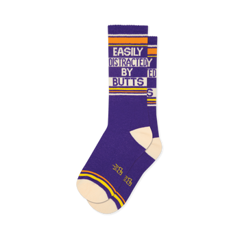 A pair of purple crew socks with "EASILY DISTRACTED BY BUTTS" text in white, orange, and cream stripes.