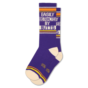 A pair of purple crew socks with "EASILY DISTRACTED BY BUTTS" text in white, orange, and cream stripes.