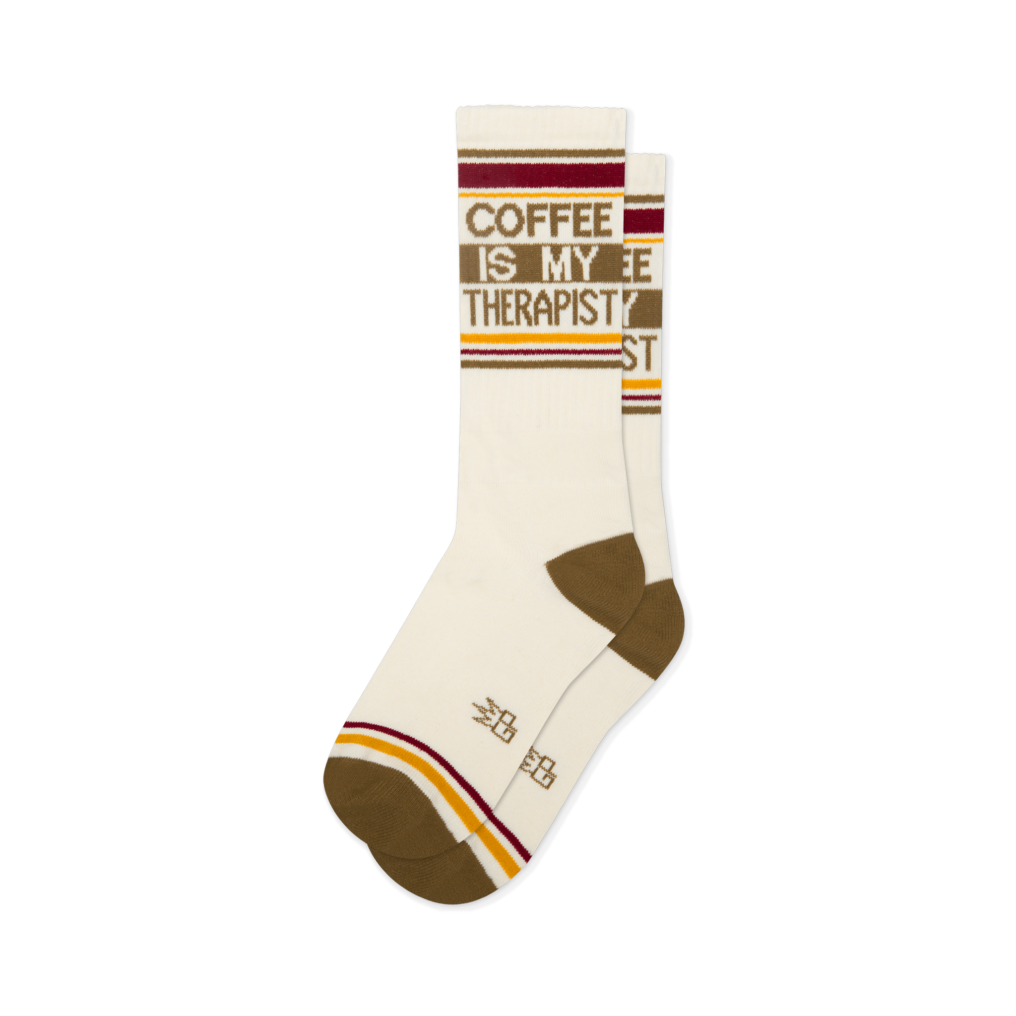 Off-white crew socks reading COFFEE IS MY THERAPIST in brown. Features brown heels, toes, and retro red and yellow stripes.