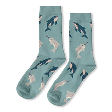Light blue crew socks featuring a scattered pattern of dark blue whales and grey spotted narwhals with striped tusks.