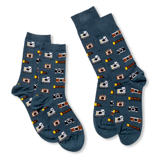 Two pairs of dark blue socks with vintage cameras and yellow film strips, arranged flat and slightly overlapping each other.