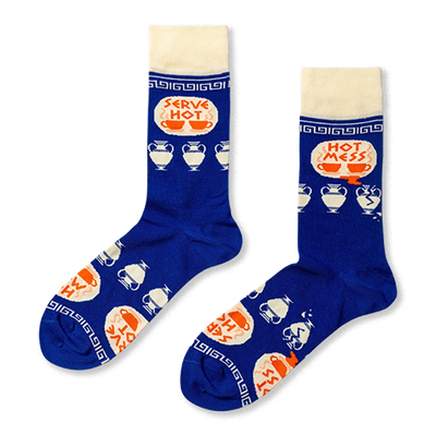 Pair of royal blue crew socks with cream cuffs, heels, toes. Features 'Serve Hot' and 'Hot Mess' text with cups and broken Greek vases.
