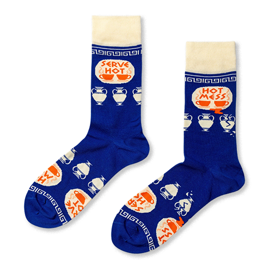 Pair of royal blue crew socks with cream cuffs, heels, toes. Features 'Serve Hot' and 'Hot Mess' text with cups and broken Greek vases. }}