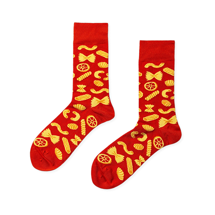 Pair of red crew socks with a repeating yellow pattern of various pasta shapes like farfalle, fusilli, and rotelle. }}