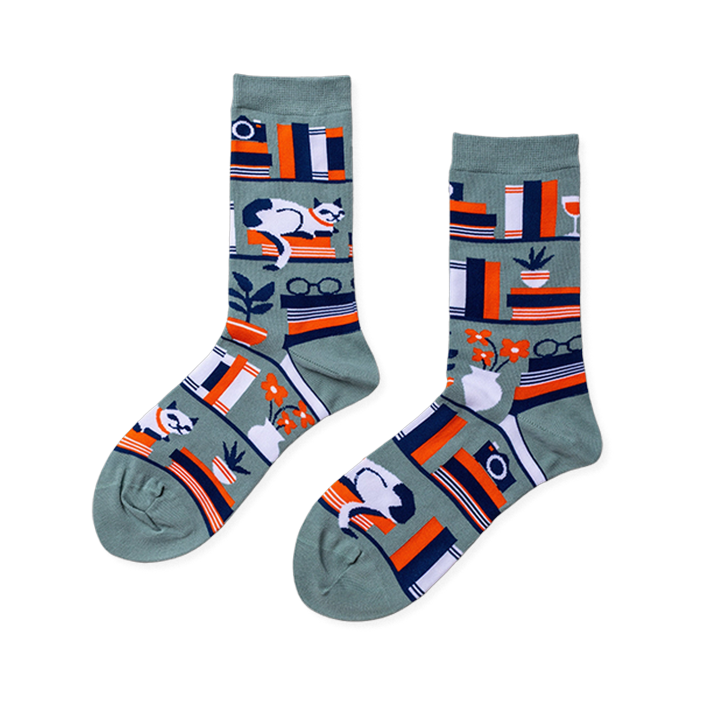 Pair of crew socks in sage green with a bookshelf pattern. Design includes books, a white cat, plants, and reading glasses.