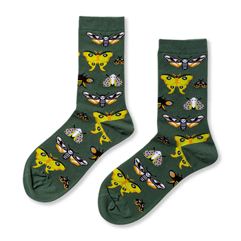 Pair of crew socks in dark green, patterned with various moths including yellow, black and white skull-like, and grey speckled designs.