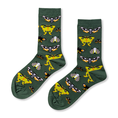 Pair of crew socks in dark green, patterned with various moths including yellow, black and white skull-like, and grey speckled designs.
