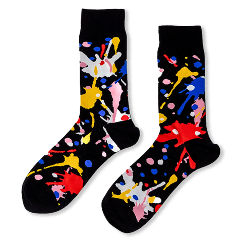Black crew socks with bright, messy paint splatters in red, blue, yellow, pink, and white.