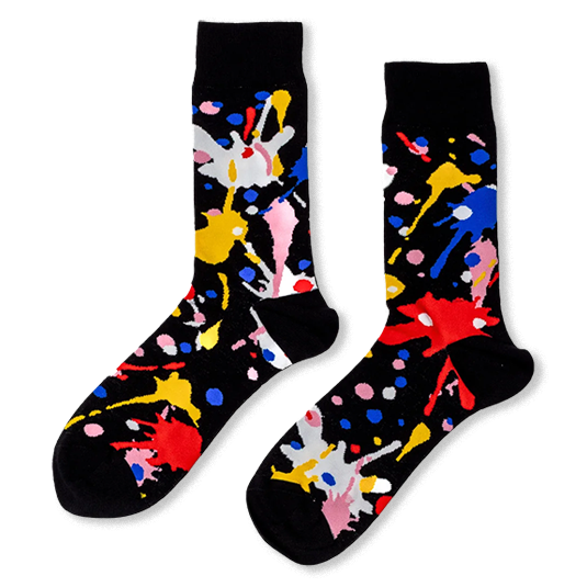 Black crew socks with bright, messy paint splatters in red, blue, yellow, pink, and white.
