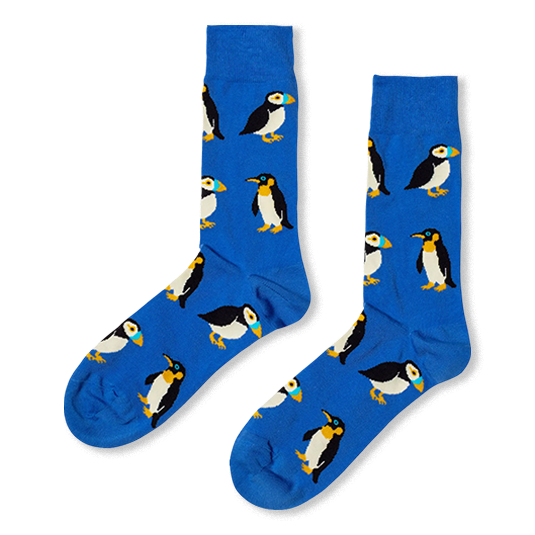 Royal blue crew socks featuring a repeating pattern of puffins with colorful beaks and penguins with yellow neck markings.