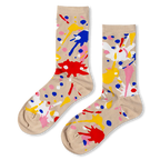 Beige crew socks featuring a chaotic pattern of bright red, blue, yellow, pink, and white paint splatters and dots.