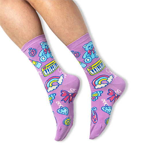 [lf] A person wearing purple crew socks featuring a retro charm pattern with teddy bears and keyboards on a black background.