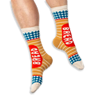 [lf] A person wearing tan striped socks with blue gingham details and a red BREAD label on a black background.