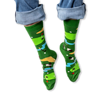 [lf] A person wearing rolled-up blue jeans and green crew socks featuring a colorful golf course pattern with flags and carts.