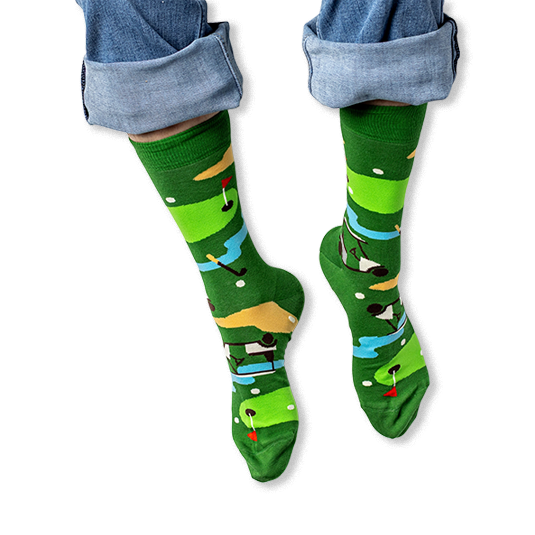 [lf] A person wearing rolled-up blue jeans and green crew socks featuring a colorful golf course pattern with flags and carts.
