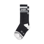 Pair of black crew socks with white stripes and 'DADDY' text.  Sporty and playful design.
