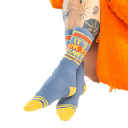 Close-up shot: 'It's Ok to Fart' socks on a person's legs; the focus is on the socks' design and texture.