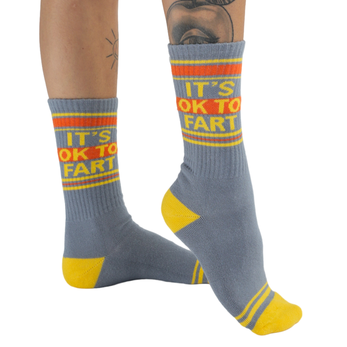 Studio shot: Pair of 'It's Ok to Fart' socks displayed on a white background, showcasing the full design.