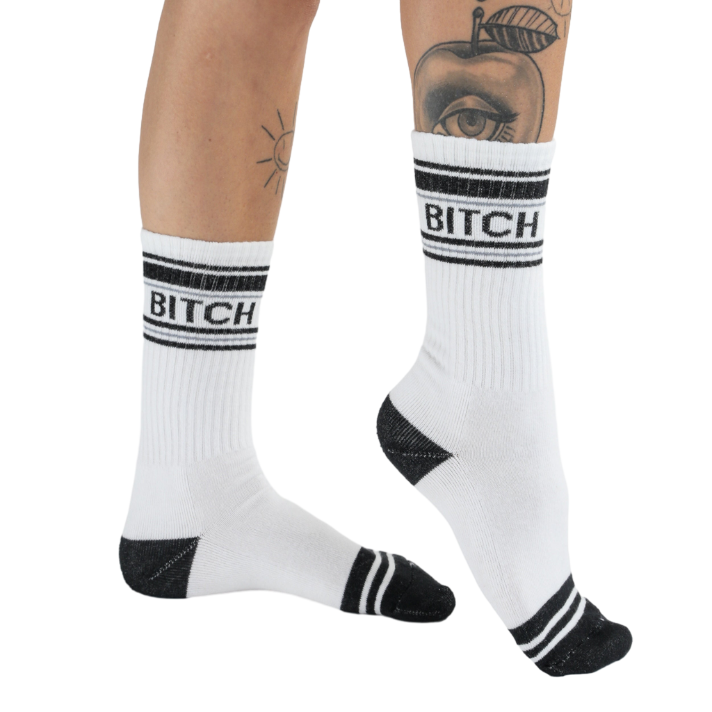 Lifestyle shot of 'Bitch' socks on a woman's legs, showcasing the fit and style.