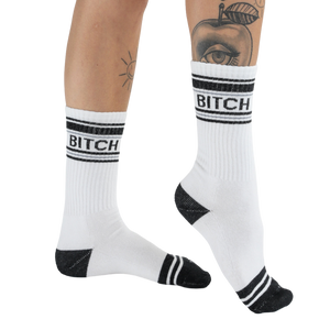 Lifestyle shot of 'Bitch' socks on a woman's legs, showcasing the fit and style.
