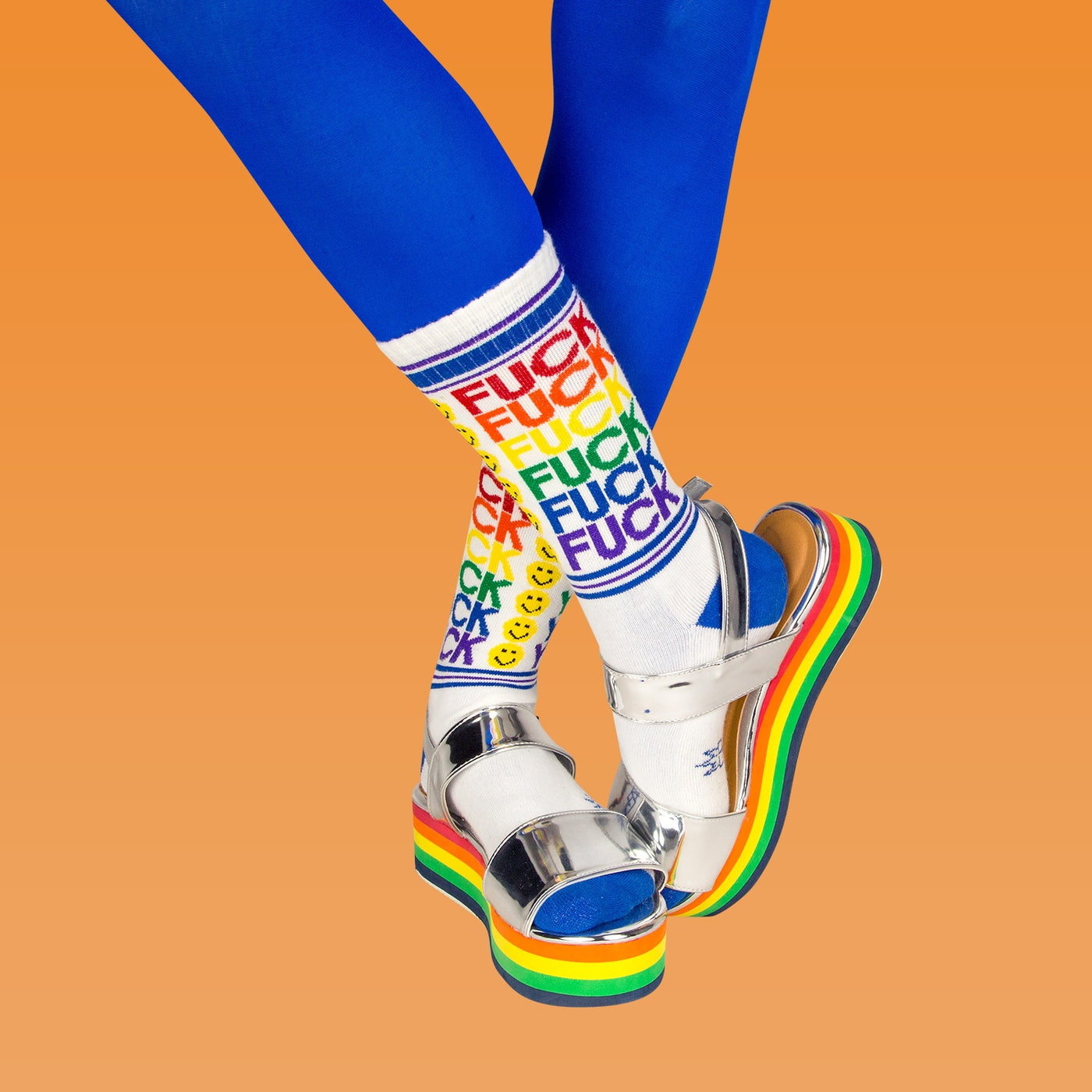Lifestyle shot of model wearing 'Fuck You' socks with silver platform sandals and blue tights. [lf]