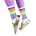 Lifestyle shot of model wearing 'Fuck You' socks with silver sneakers and purple tights.
