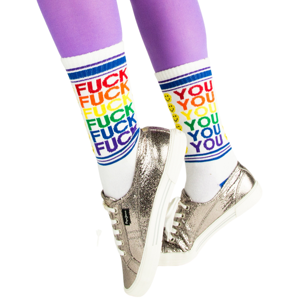 Lifestyle shot of model wearing 'Fuck You' socks with silver sneakers and purple tights.