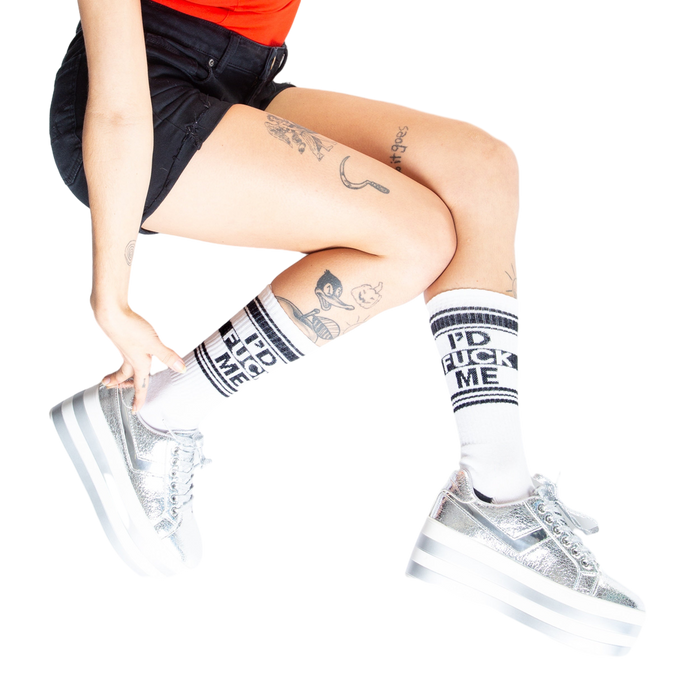 Lifestyle shot: Person wearing white 'I'd Fuck Me' socks with silver platform shoes.