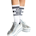Lifestyle shot: Person wearing white 'I'd Fuck Me' socks, sitting with legs apart.