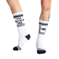 Close-up shot of a person's legs wearing white 'I'd Fuck Me' socks and silver platform shoes.
