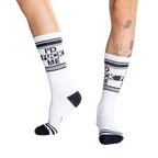 Close-up shot of a person's legs wearing white 'I'd Fuck Me' socks and silver platform shoes.