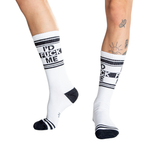 Close-up shot of a person's legs wearing white 'I'd Fuck Me' socks and silver platform shoes.