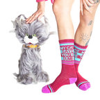 Lifestyle photo showing a model wearing the 'My Cat Says You're Dumb' socks with a fluffy gray cat toy.