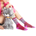 Another lifestyle shot of a model wearing the socks and sitting with a gray cat toy.