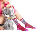 Another lifestyle shot of a model wearing the socks and sitting with a gray cat toy.