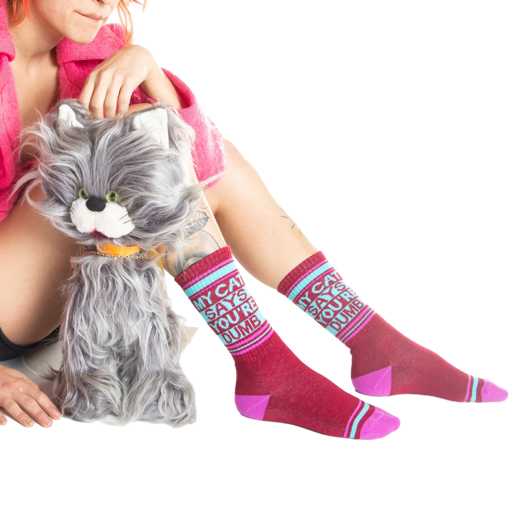 Another lifestyle shot of a model wearing the socks and sitting with a gray cat toy.