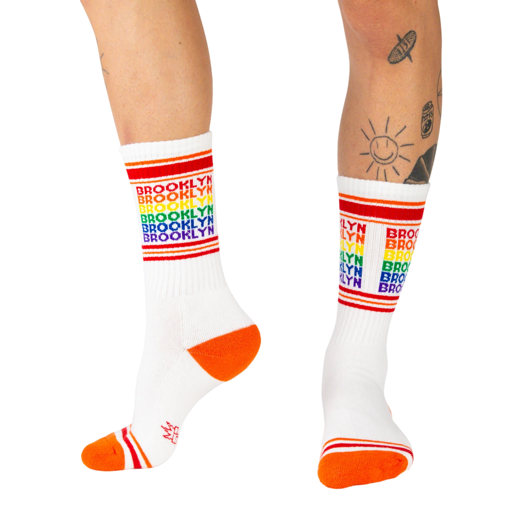 Lifestyle shot of a person wearing the Brooklyn rainbow socks, showing how they look when worn.