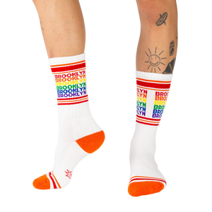 Lifestyle shot of a person wearing the Brooklyn rainbow socks, showing how they look when worn.