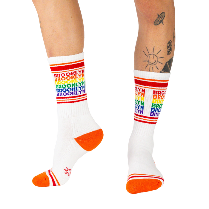 Lifestyle shot of a person wearing the Brooklyn rainbow socks, showing how they look when worn.
