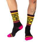 Lifestyle photo showing a person wearing the black 'Everything Hurts And I'm Dying' crew socks.