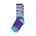 Pair of purple and teal crew socks with the text 'Be The Person Your Dog Thinks You Are' written vertically.