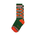 Pair of crew socks in green, orange, and purple.  Features a retro-style stripe pattern and the text 'Home Is Where The Weed Is'.
