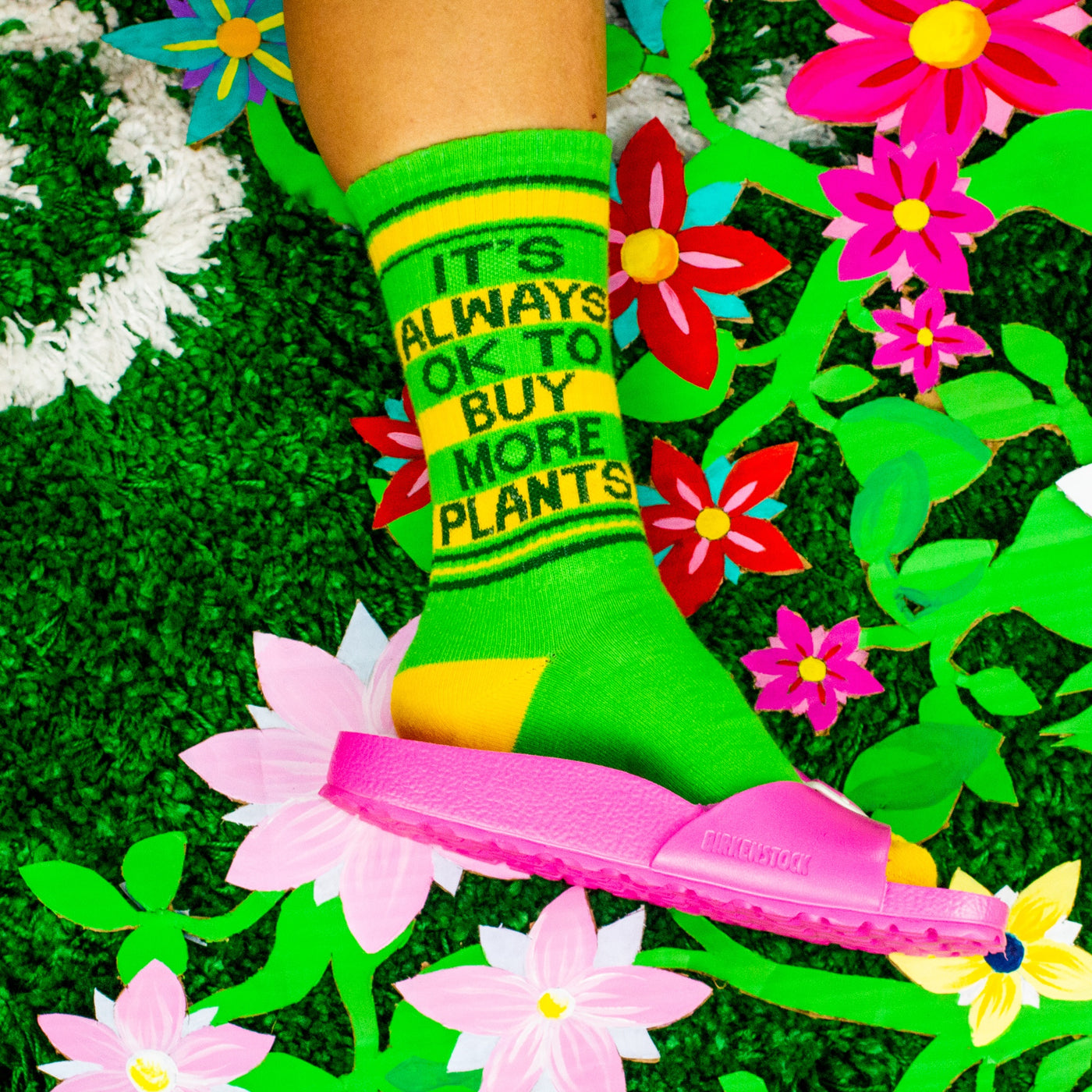 A close-up shot of the socks on a person's feet against a floral background. [lf]