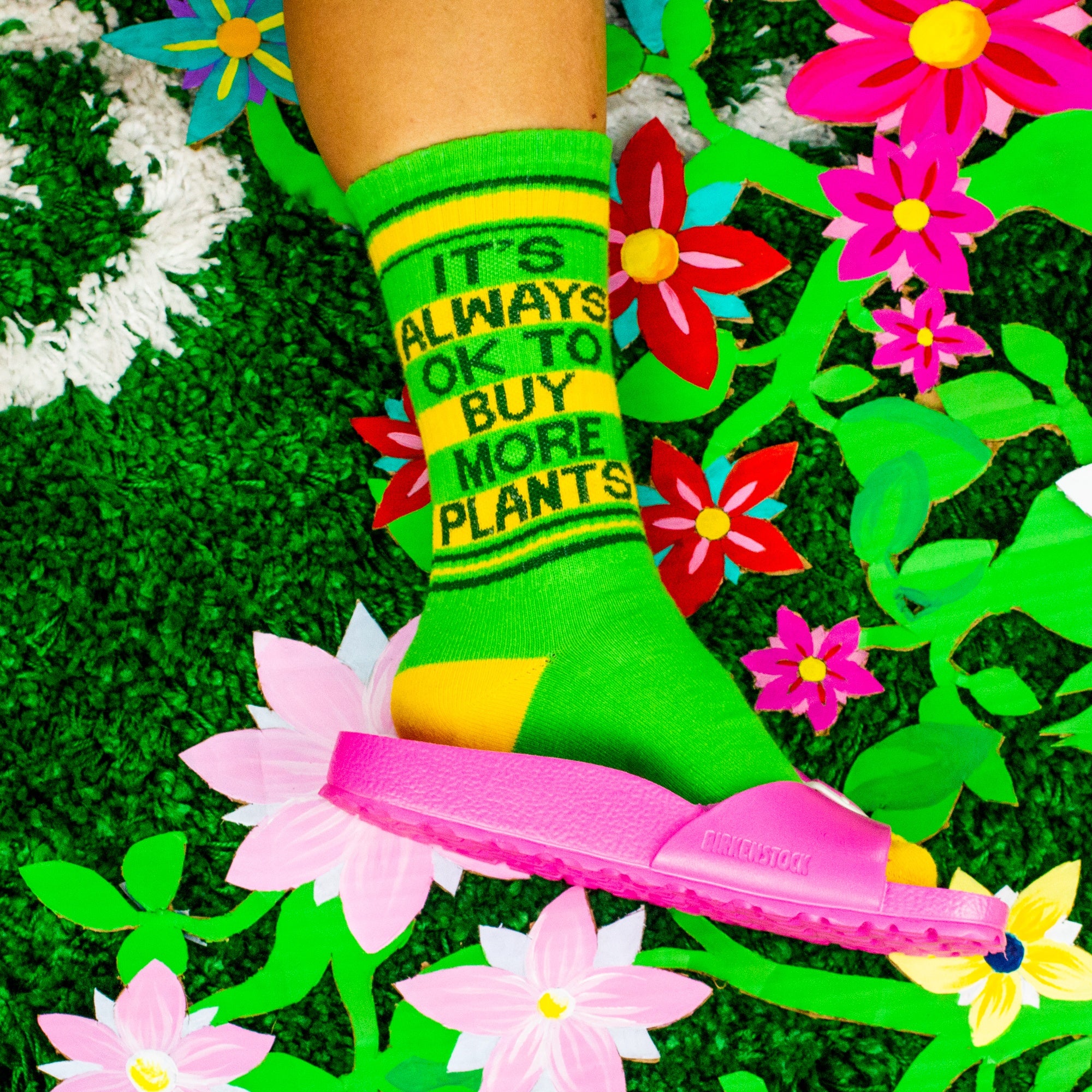 A close-up shot of the socks on a person's feet against a floral background. [lf]